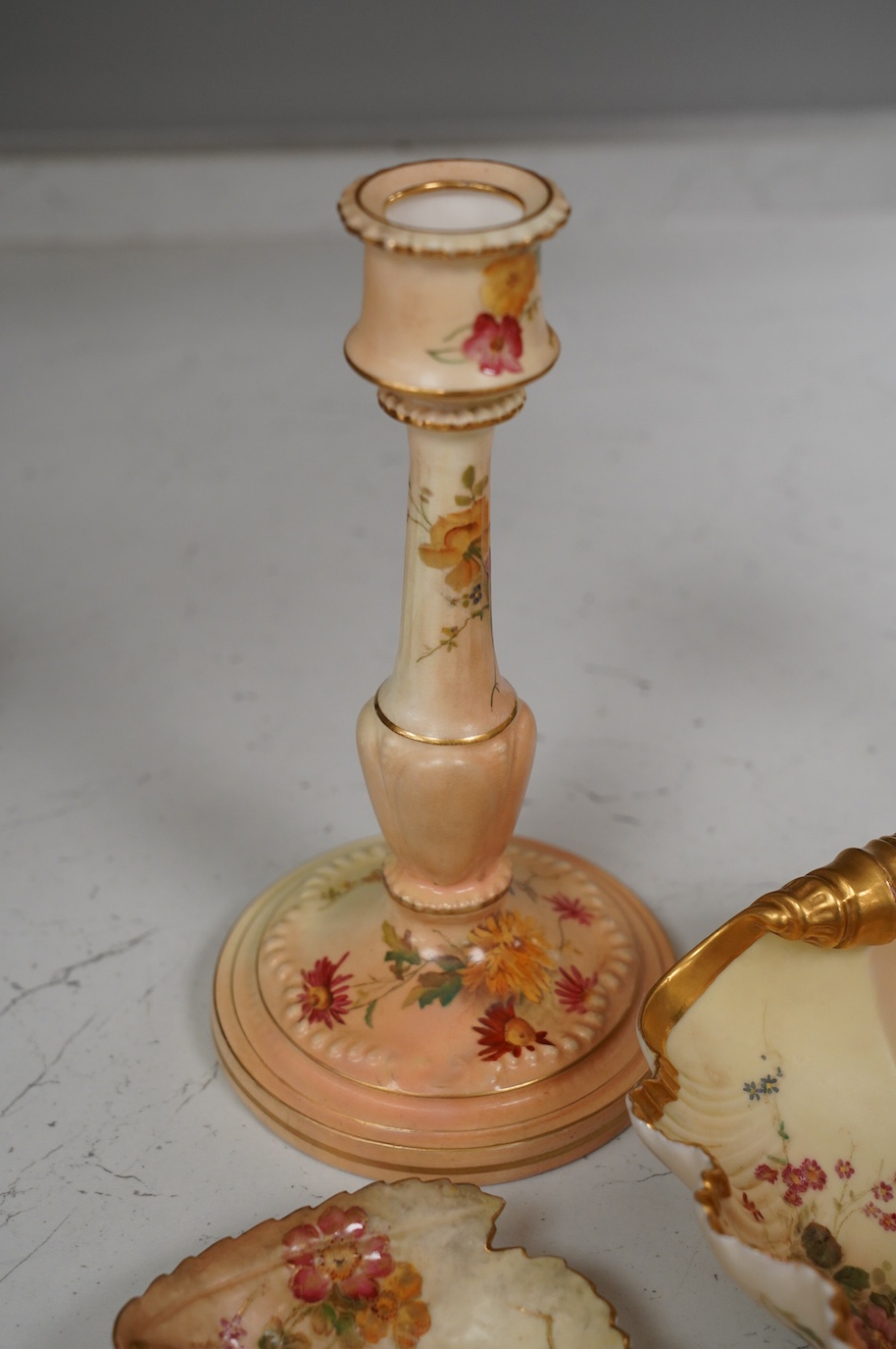 A pair of Royal Worcester blush ivory candlesticks, three bon bon dishes and a pair of plates, tallest 20cm. Condition - mostly good, some damage